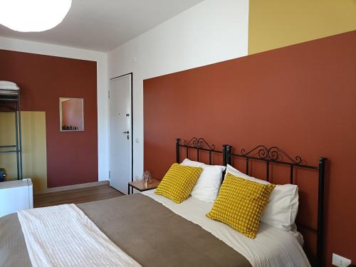 a bedroom with a large bed with yellow pillows at B&B Sbarco dei 1000 in Marsala