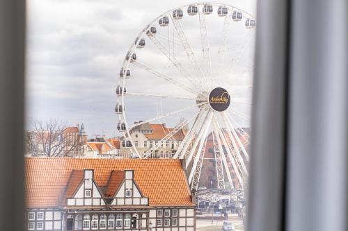 a ferris wheel in front of a city at Chrobry Apartamenty Gdańsk Grodzka 10 in Gdańsk