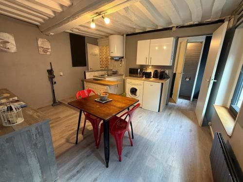 une petite cuisine avec une table en bois et une salle à manger dans l'établissement La Tranquilité, à Saint-Valery-en-Caux