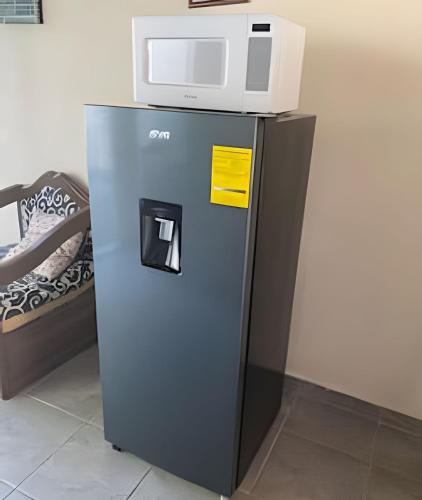 a refrigerator with a microwave on top of it at C9 Casas la colmena a 3 min playa alberca 2 rec. in Peñita de Jaltemba