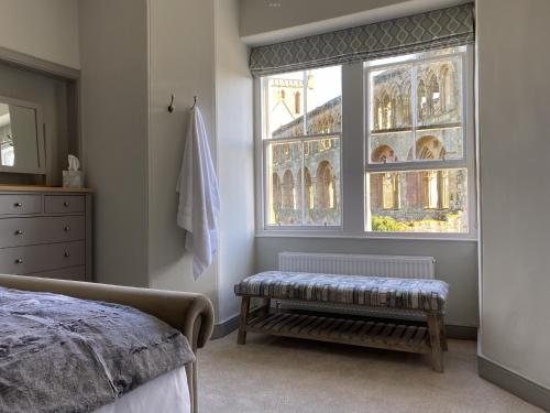 a bedroom with a bench in front of a window at Abbey House Charming traditional historic house in Jedburgh