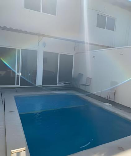 a swimming pool in a building with a blue pool at C9 Casas la colmena a 3 min playa alberca 2 rec. in Peñita de Jaltemba