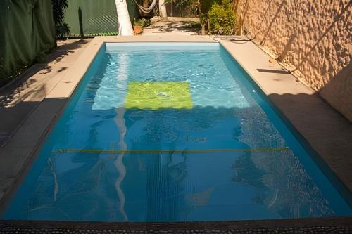 a swimming pool with a green object in the water at C1 Alberca privada a 5 min de la playa y manglar! in La Peñita de Jaltemba