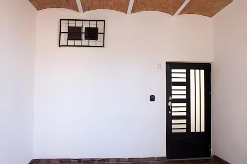 a black door in a room with a white wall at C7 Casas la colmena a 3 min playa alberca 4 rec, in Peñita de Jaltemba
