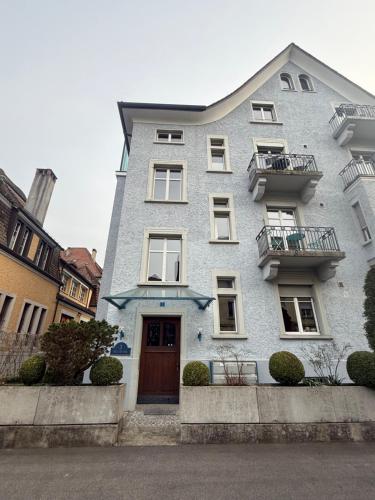 a gray building with a door and a balcony at Haus Zum Park - The apartment in Baden