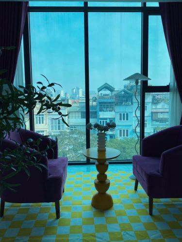 a living room with a table and a large window at The Grand Diamond C Tuong Mai in Hanoi