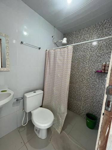 a bathroom with a toilet and a shower and a sink at Casa com Piscina em Enseada in Cabo de Santo Agostinho