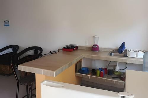 a kitchen with a counter with a sink and chairs at C3A Casas la colmena a 3 min playa alberca 2 nivel in Peñita de Jaltemba