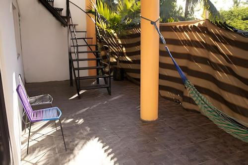 a porch with a hammock and a purple chair at C3A Casas la colmena a 3 min playa alberca 2 nivel in Peñita de Jaltemba