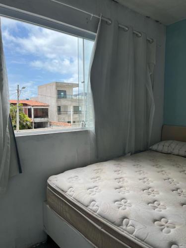 a bed in a room with a window at Casa com Piscina em Enseada in Cabo de Santo Agostinho