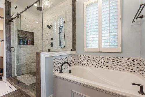 a white bathroom with a tub and a shower at Lakeside Grand Villa - Lone Star State Little Elm in Little Elm