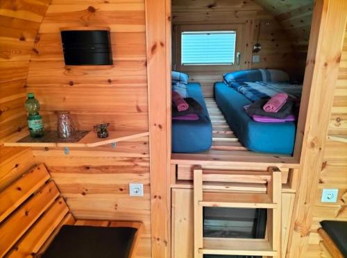 a room with a couch in a tiny house at Campingfass in Weener