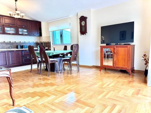 un salon avec une table, des chaises et une télévision dans l'établissement Adriatic Home, à Pržno