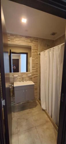 a bathroom with a tub and a sink and a mirror at Departamentos Casa de playa in Necochea