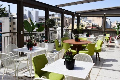 a patio with tables and chairs on a balcony at Urban Frame Acropolis in Athens