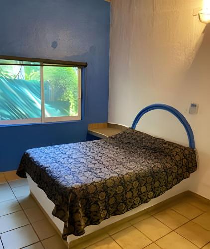 a bedroom with a bed in a room with a window at C1A 5 Alberca privada a 5 min de la playa in Peñita de Jaltemba