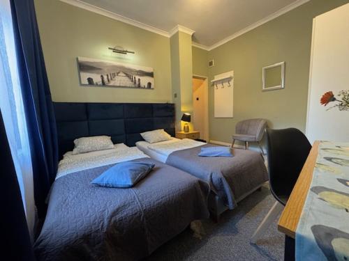pokój hotelowy z dwoma łóżkami i stołem w obiekcie Jazzgot Apartamenty w Zielonej Górze