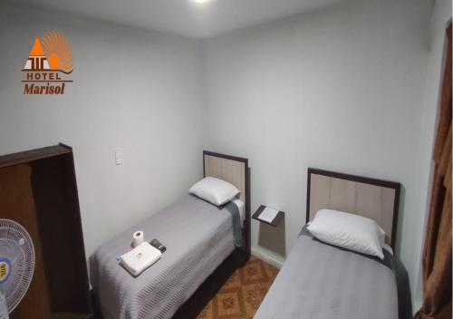 two beds sitting next to each other in a room at Hotel Marisol in Iquique