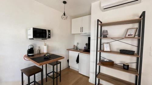- une cuisine avec une table et un bar dans une pièce dans l'établissement Studio proche plage avec jardinet et parking - Casa Garcia, à Villeneuve-Loubet