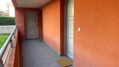 un couloir orange avec une porte et du carrelage dans l'établissement Studio proche plage avec jardinet et parking - Casa Garcia, à Villeneuve-Loubet