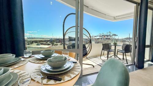 a dining room with a table and a large window at Le Mirage- Stylish, central apartment with pools, sauna, more in Auckland