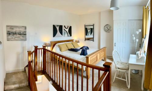 a bedroom with a bed and a staircase with a desk at Sunny Hill Cottage Milford with fabulous views near Belper Duffield in Belper