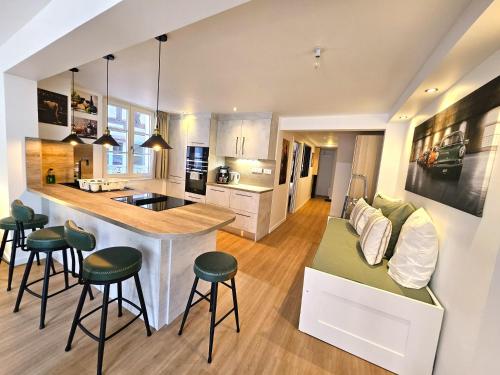 - une cuisine et un salon avec un bar et des tabourets dans l'établissement Magnifique T2-Chez François et Kamila - Centre historique- Parking et balcon privatif, à Colmar