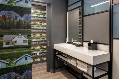 a bathroom with a sink and a mirror at Aloft Sacramento Airport Natomas in Sacramento