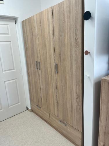 a pair of wooden cabinets in a room next to a door at 3 Barát Apartman in Kehidakustány