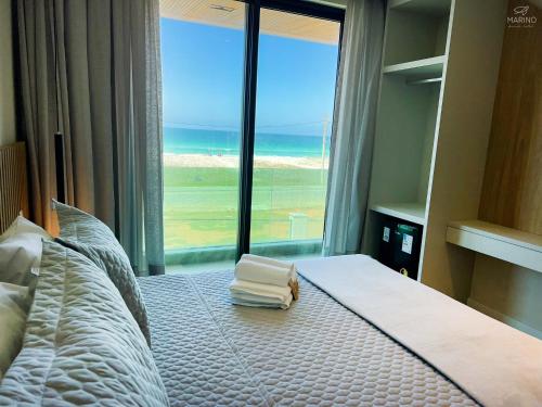 a bedroom with a bed with a view of the ocean at Marino Beach Hotel in Cabo Frio