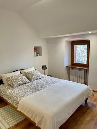 a bedroom with a large white bed and a window at Istrian house Casa del nonno in Šmarje