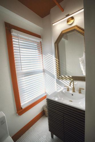 a bathroom with a sink and a mirror and a window at Peninsula Bed & Cocktails in St Petersburg