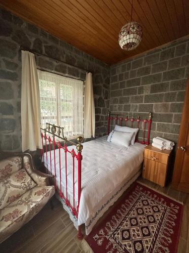 a bedroom with a bed and a stone wall at Bahçeli Taş Villa in Trabzon
