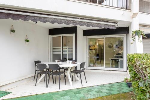 une table et des chaises sur le patio d'une maison dans l'établissement Chez Alex' & Sandy - Magnifique appartement avec parking et accès plage, à La Grande Motte