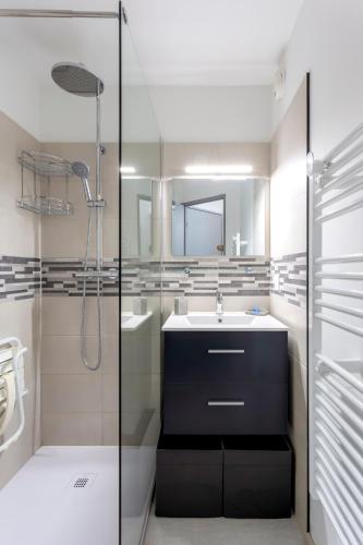 une salle de bain avec un lavabo et une douche dans l'établissement Chez Alex' & Sandy - Magnifique appartement avec parking et accès plage, à La Grande Motte