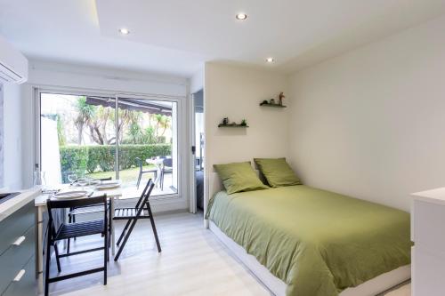 une chambre avec un lit, un bureau et une fenêtre dans l'établissement Chez Alex' & Sandy - Magnifique appartement avec parking et accès plage, à La Grande Motte