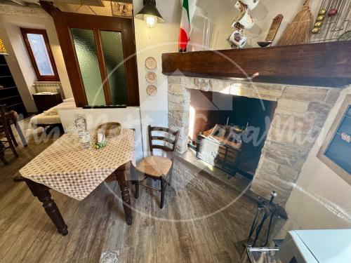 a living room with a table and a fireplace at La Scalinatella "UnaNotteaCasaMia" in Sacrofano