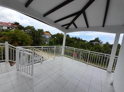 a white balcony with a white railing and trees at LE VERDOYANT in Sainte-Anne