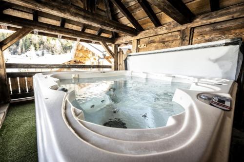 une baignoire jacuzzi au milieu d'une maison dans l'établissement Les Chalets Du Cocoon - CHALET PIERRA MENTA 2 MAE-1621, à Aime La Plagne