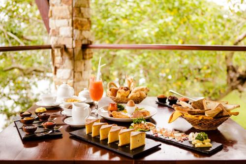 蒂瑟默哈拉默Thaulle Ayurveda Resort - Yala的一张餐桌,里面装满了食物、饮料和小吃