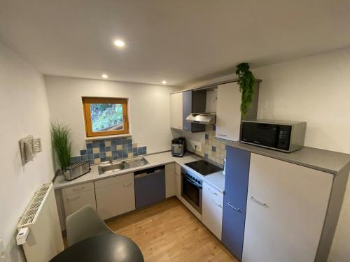 a small kitchen with a refrigerator and a microwave at Gemütliche Wohnung ruhig gelegen 75qm in Ehingen