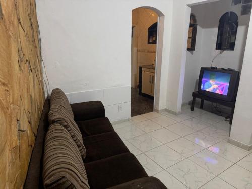 a living room with a couch and a tv at Casa do Mar in Angra dos Reis