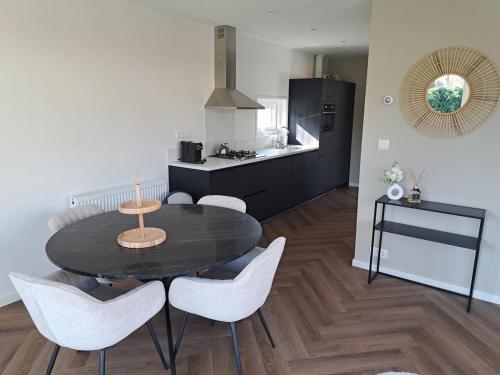 a kitchen and dining room with a table and chairs at Spring Villa Ioor in Ermelo