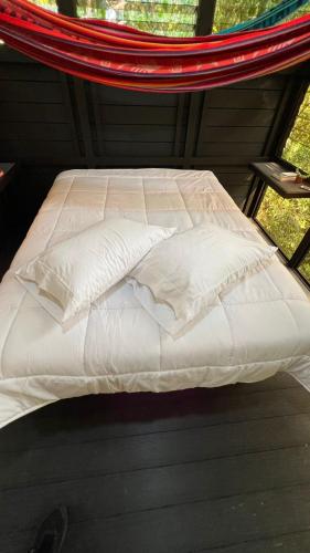 a bed in a net room with white sheets and pillows at Jungle Loft in Platanillo
