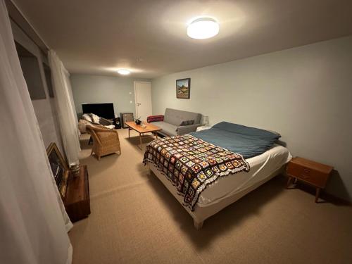 a bedroom with a bed and a living room at Vestre Karmøyveg 845 in Karmøy