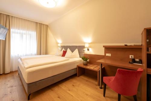 a hotel room with a bed and a desk at Hotel Mader in Steyr