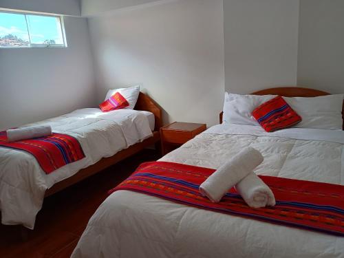 una stanza con due letti e una finestra di Hotel TIKA AYNA Cerca a la plaza de Armas CUSCO a Cuzco