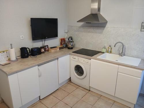 a kitchen with a sink and a washing machine at Maison de ville in Marzy