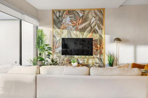 a living room with a white couch and a tv at Stunning Resort! Steps to Pool, Hot Tub and Parking in Honolulu