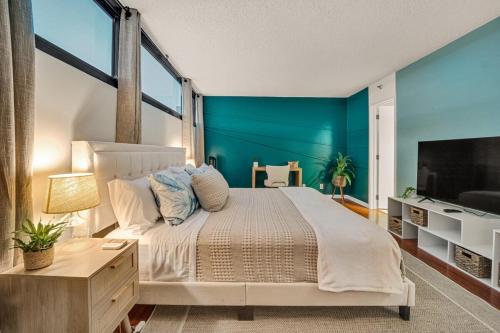 a bedroom with a large bed with blue walls at Stunning Resort! Steps to Pool, Hot Tub and Parking in Honolulu